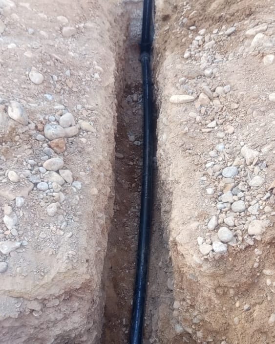 New HDPE service line on its bed in the trench
