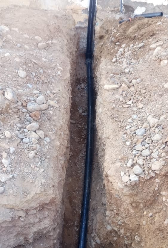 New HDPE service line on its bed in the trench